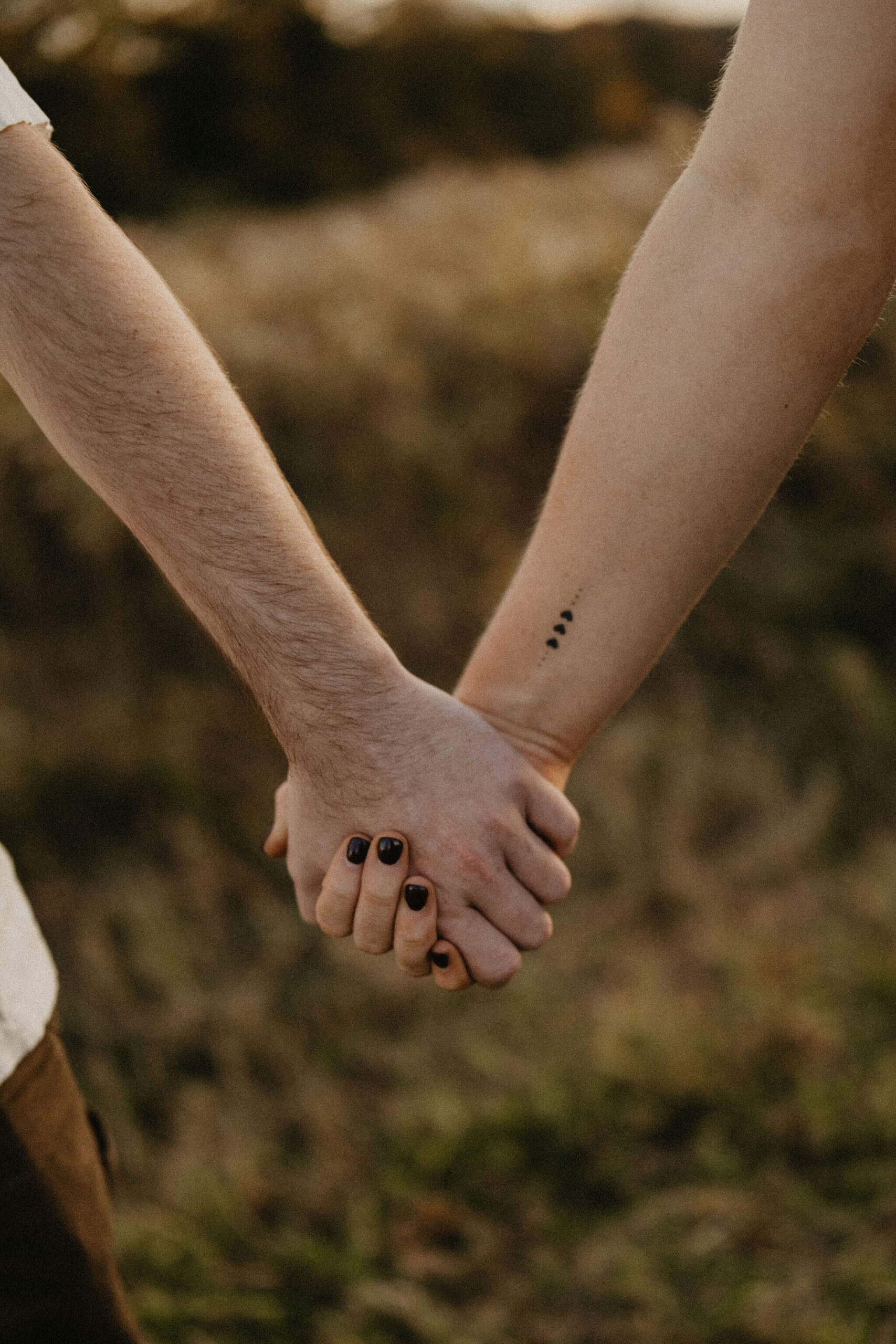 a close up image of a couple holding hands during a couples session