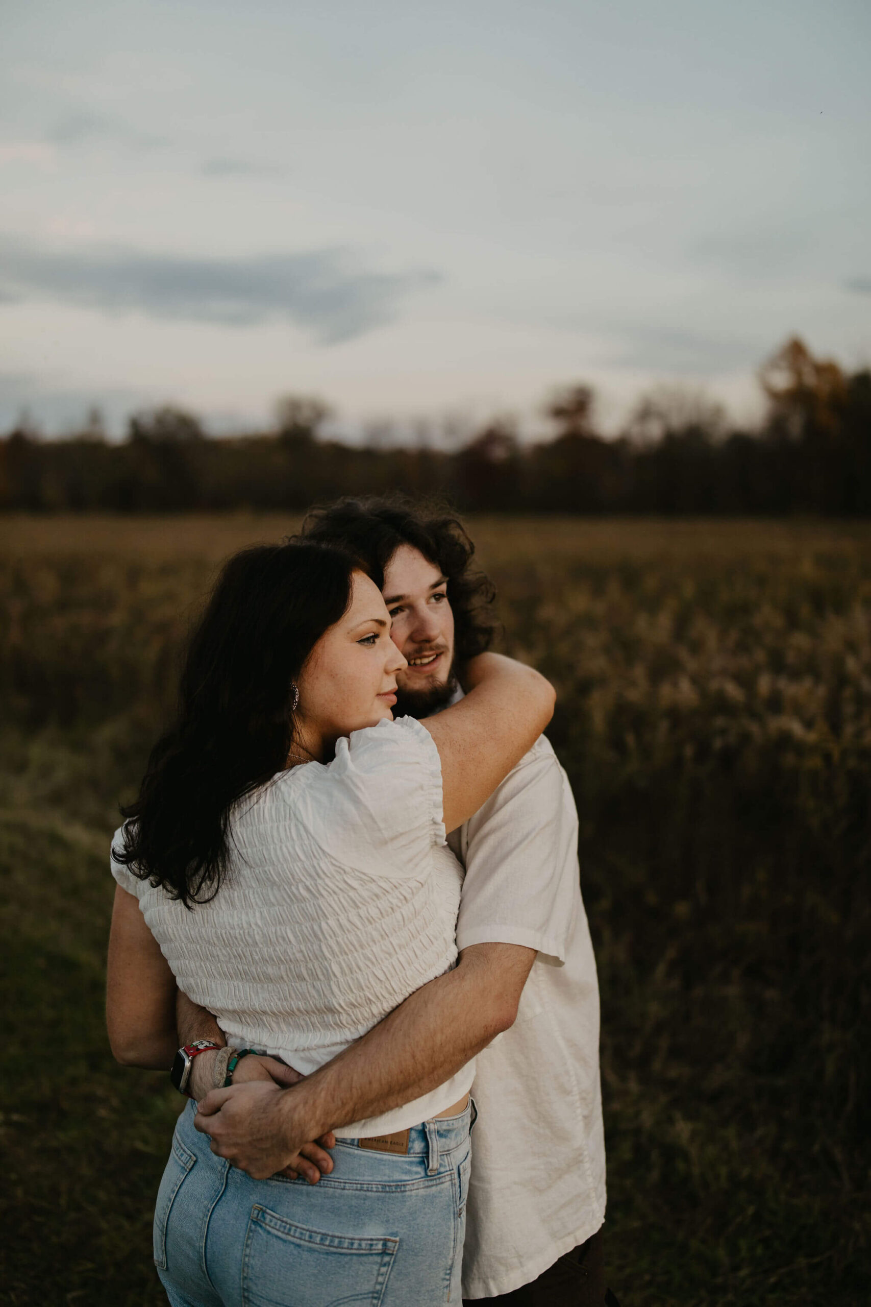 a young couple watching the moon rise during a blue hour couples session