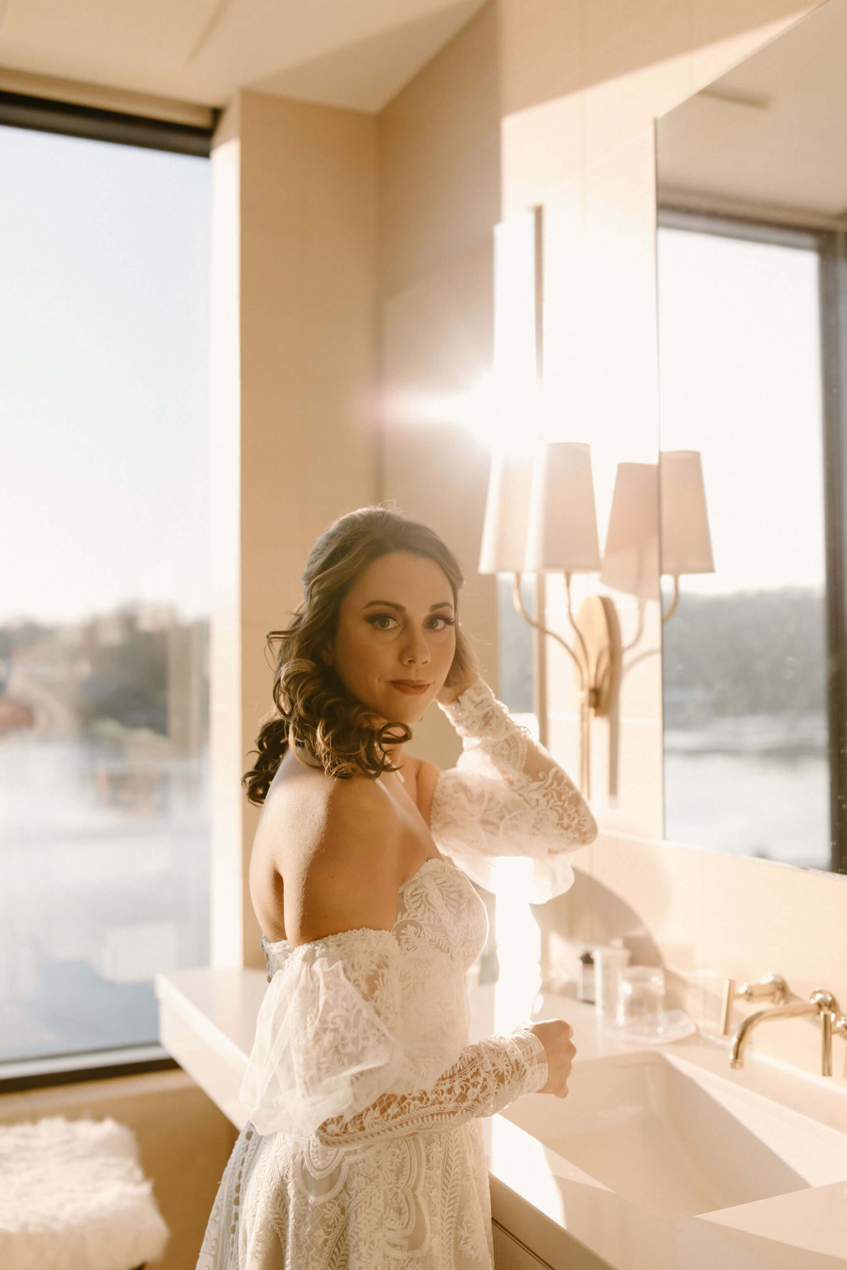 the bride looking over her shoulder toward the camera, fixing her hair - in lambertville new jersey