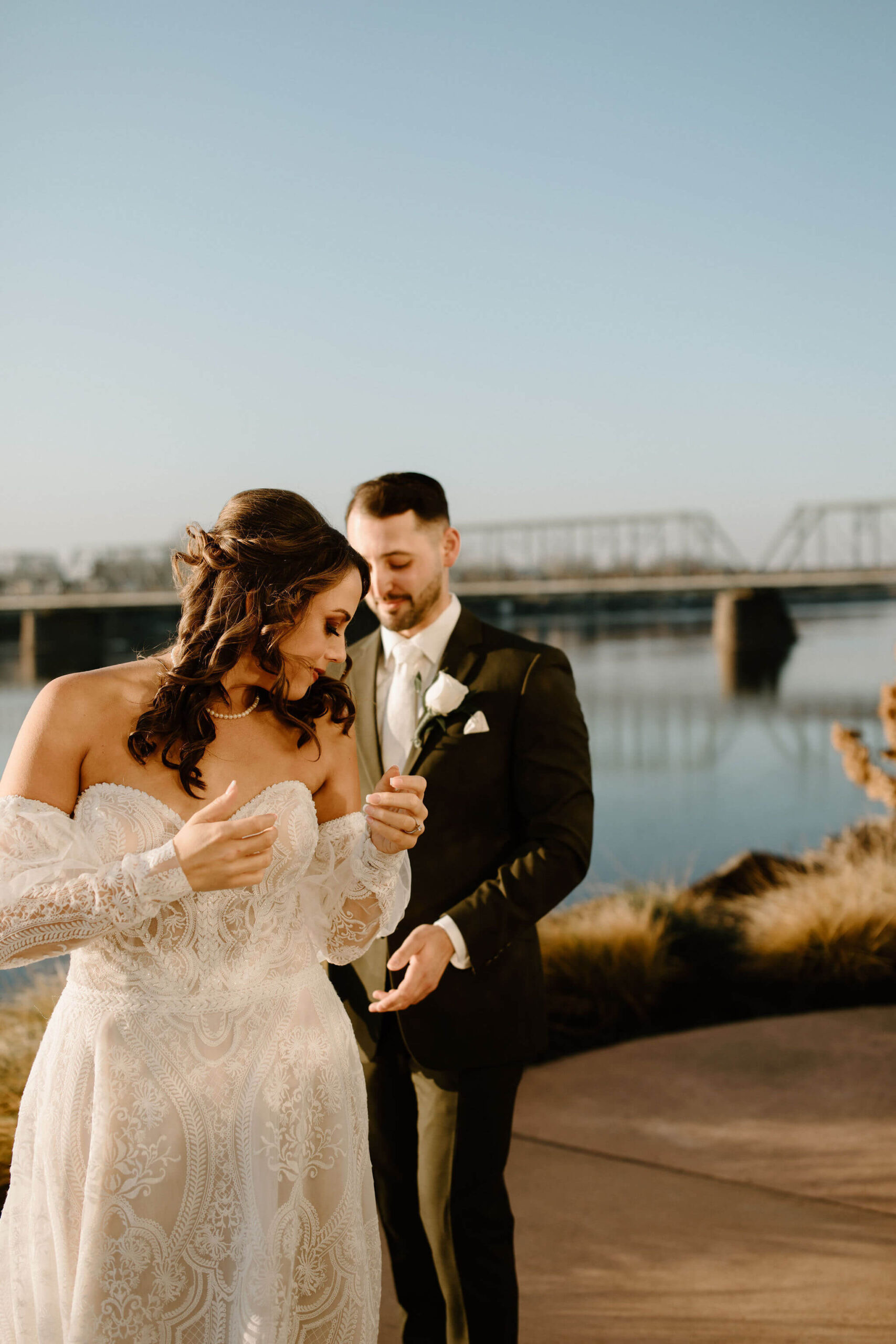 groom (brown hair, green suit) seeing his bride's (brown hair, textured off-white dress) wedding dress for the first time, at a wedding venue in lambertville new jersey