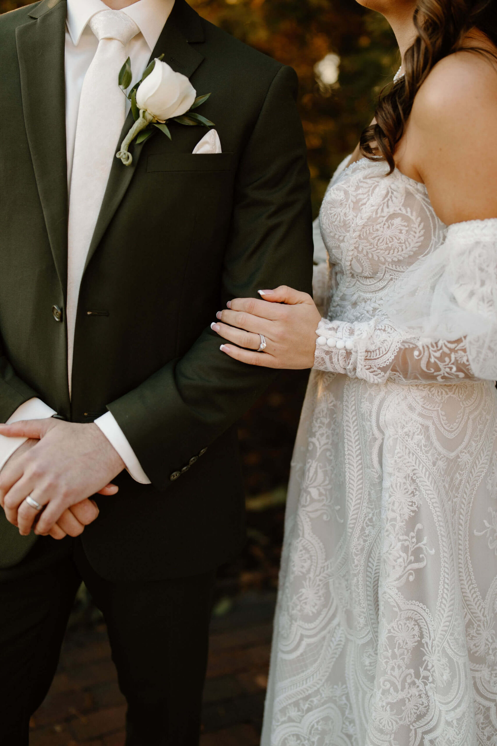 close up image of bride's left hand on groom's left arm, showcasing both of their wedding rings in lambertville new jersey