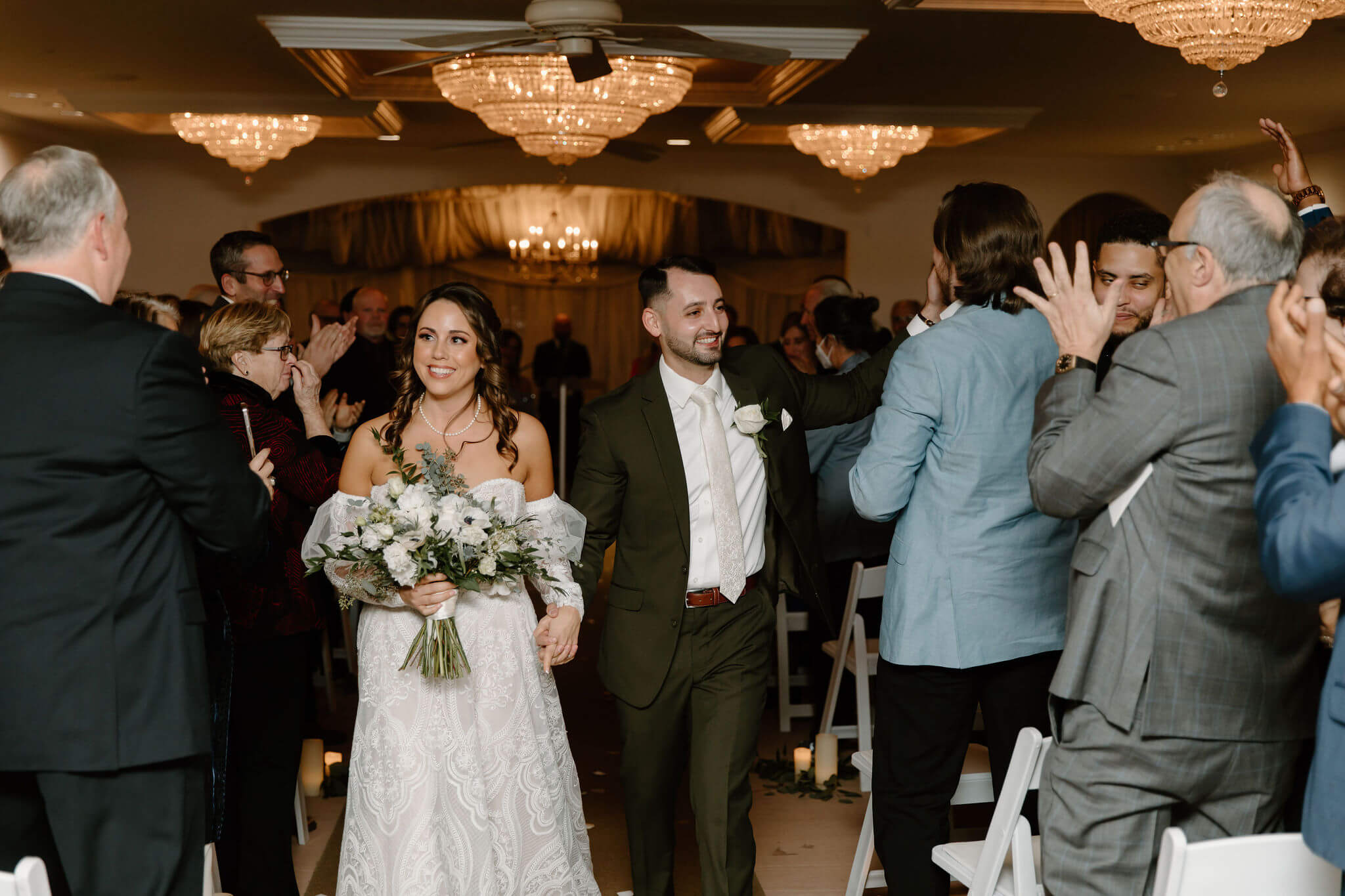 bride and groom walking up the aisle in their wedding recessional, smiling at their guests at their lambertville new jersey wedding