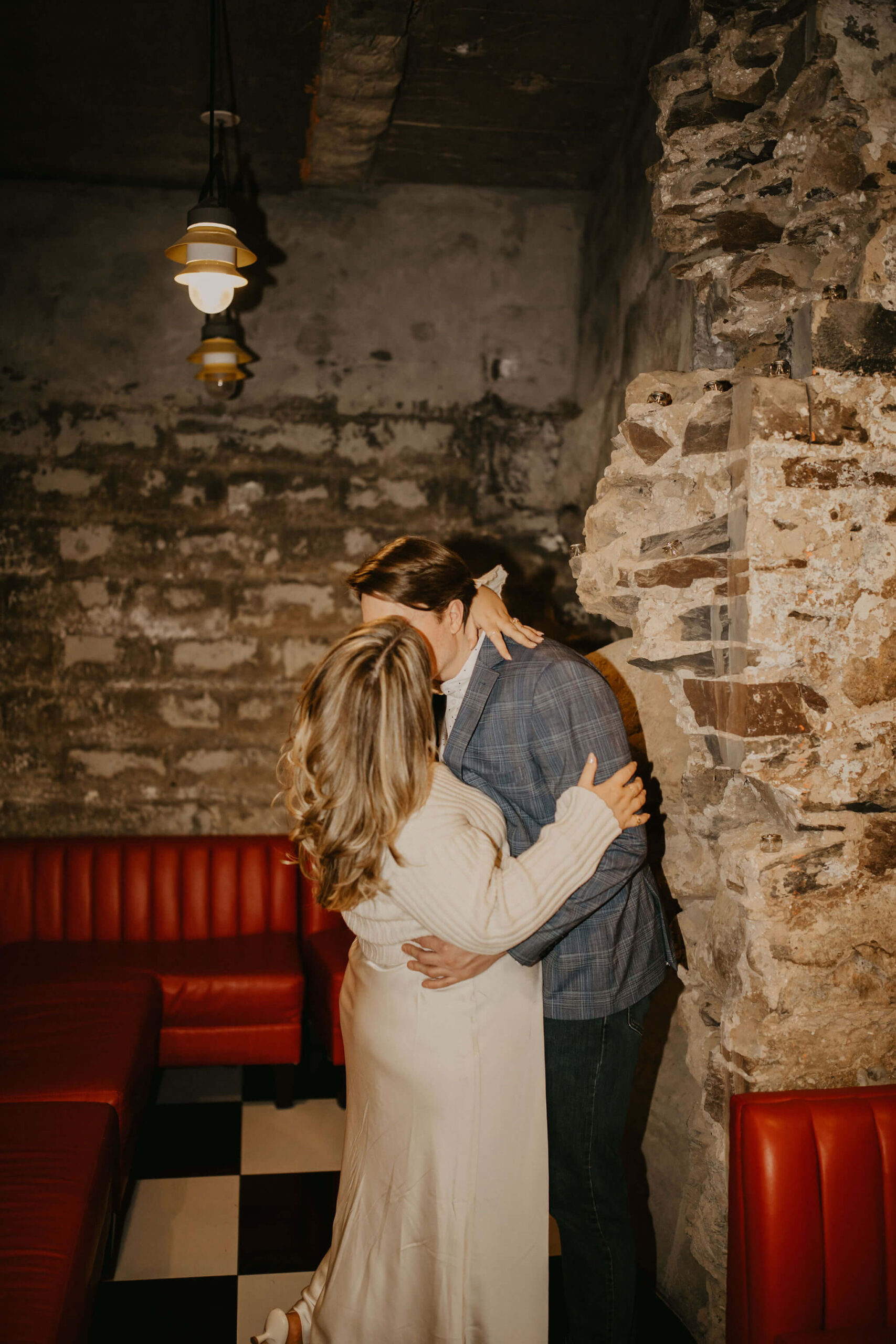 a couple kissing, with her arms around his neck and his arms around her waist during their engagement session