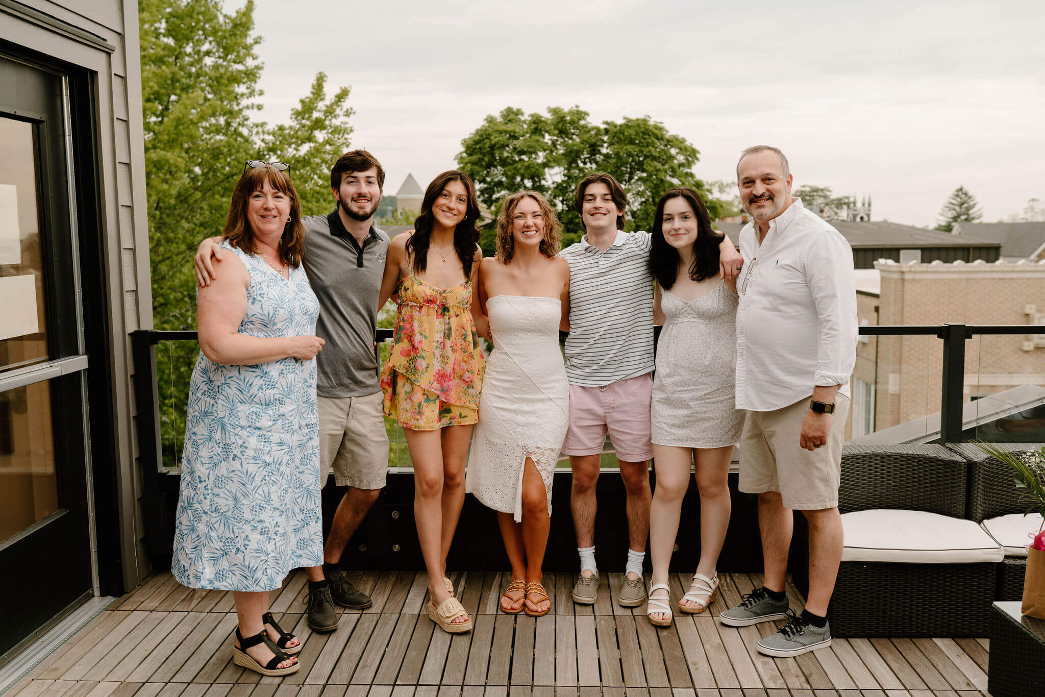 bride, groom, and groom's family smiling toward the camera