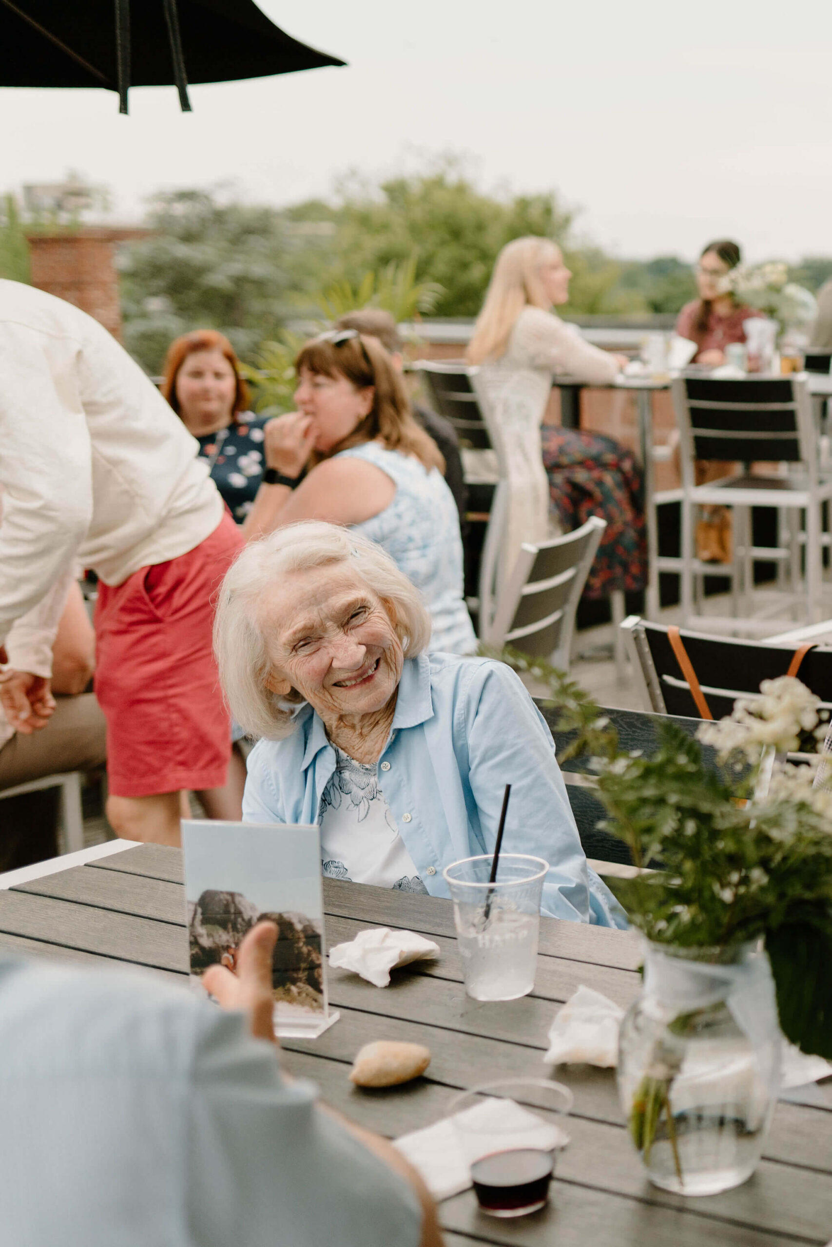 grandmother of the bride laughing and smiling at her table