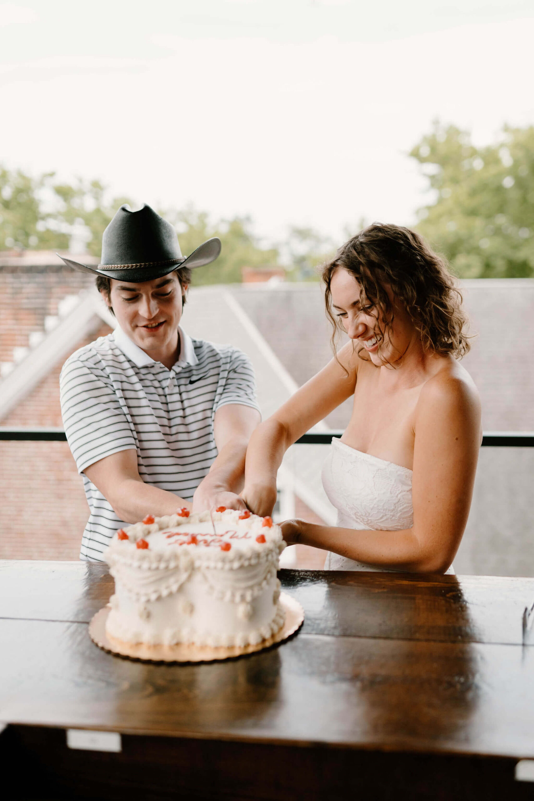 bride and groom smiling while cutting their wedding cake