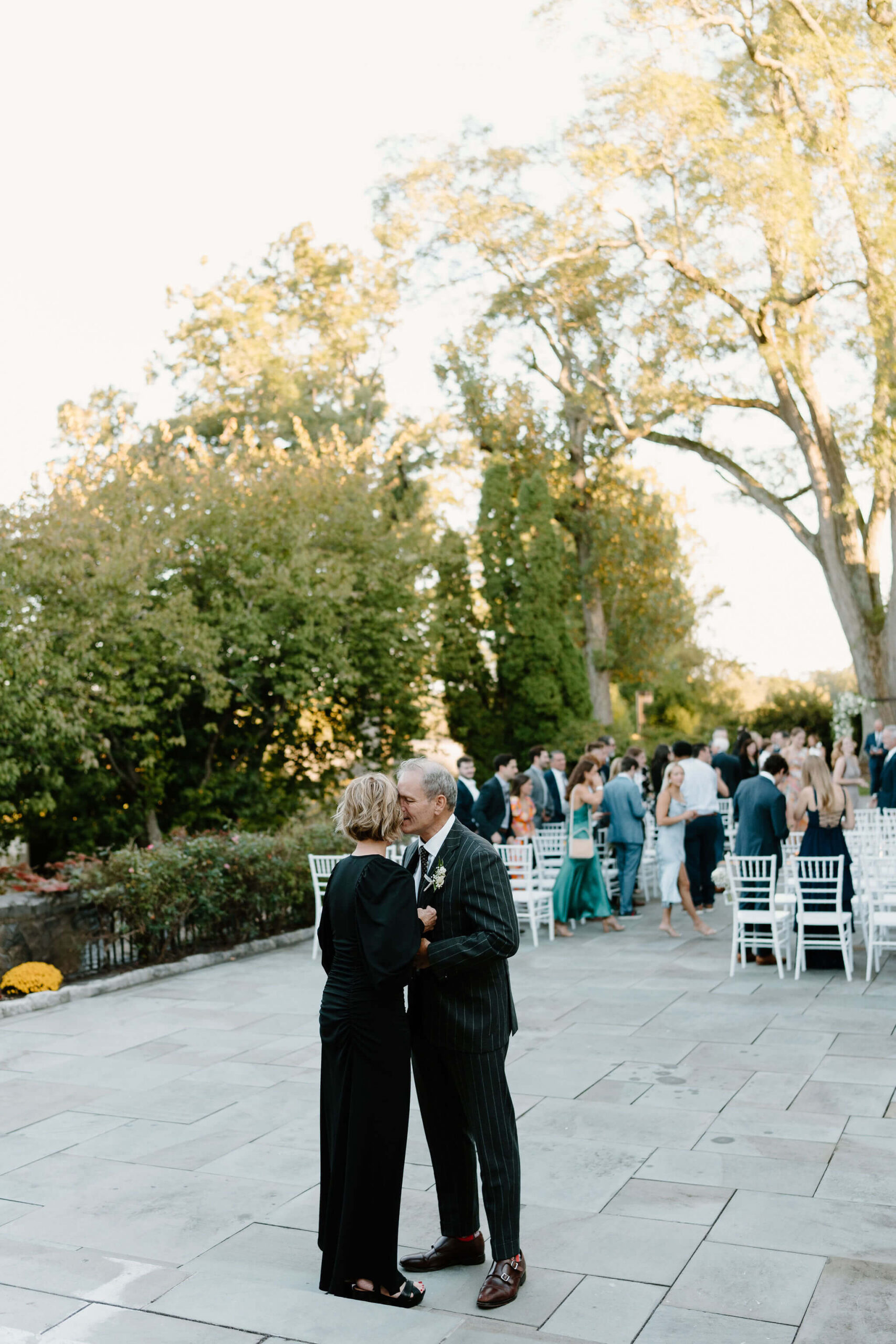 Parents of the bride kissing and embracing tearfully after the wedding ceremony
