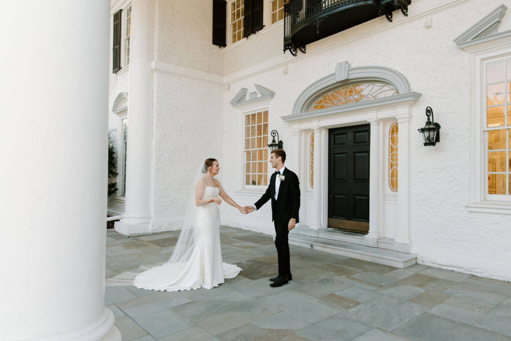 bride and groom holding hands and looking at each other on their wedding day at Radnor Valley Country Club