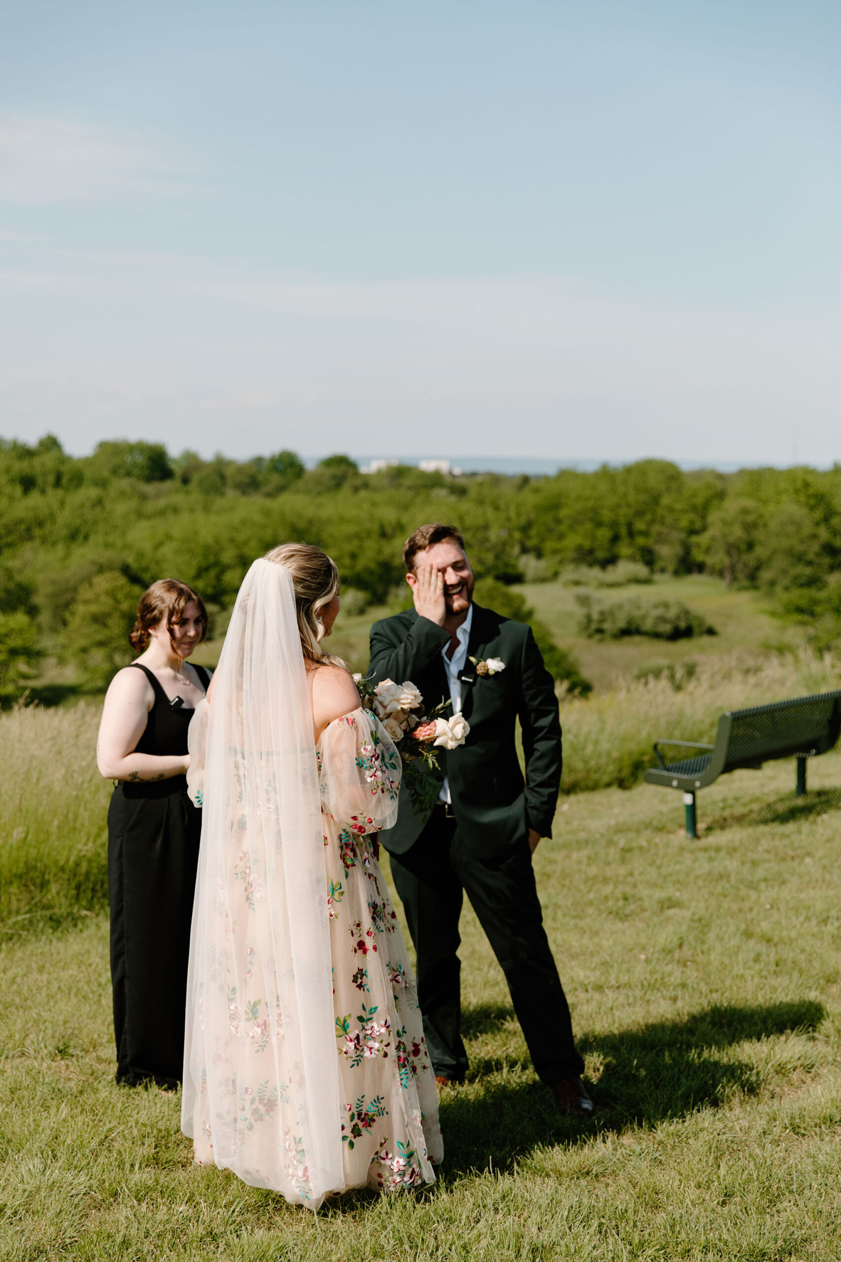 groom wiping tears from his eyes and smiling as bride reaches the end of the ceremony aisle