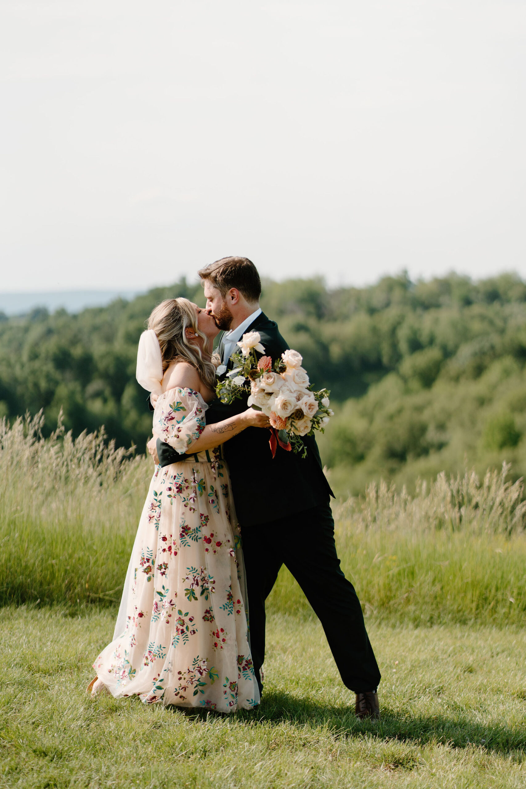 groom holding his bride at the end of the wedding ceremony and kissing her