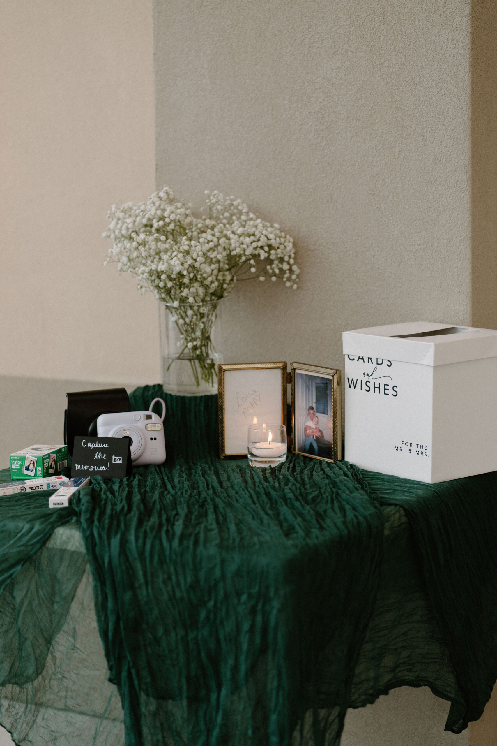 welcome table for a wedding reception with a card box and polaroid camera