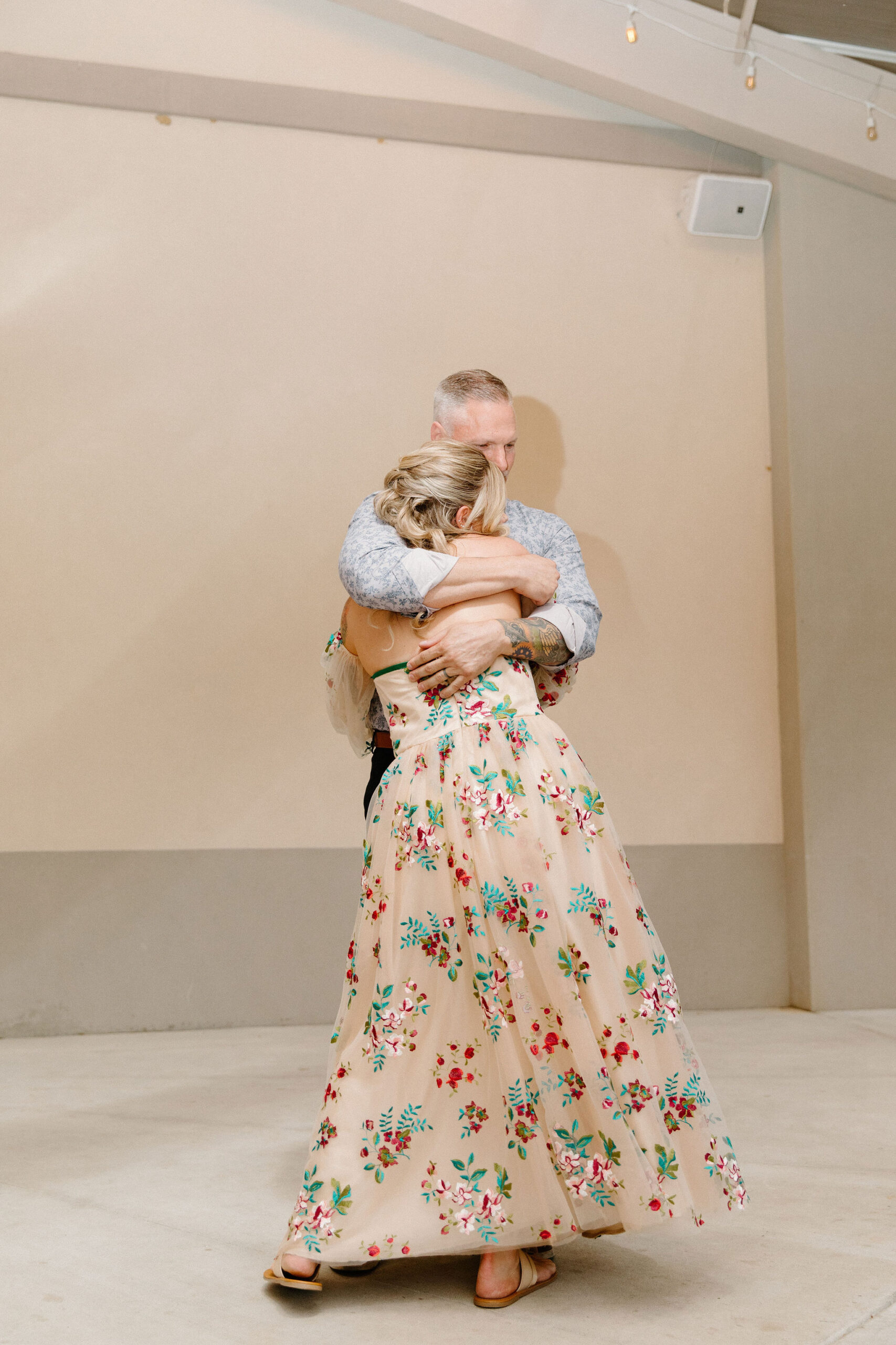 bride and her father figure embracing for their first dance
