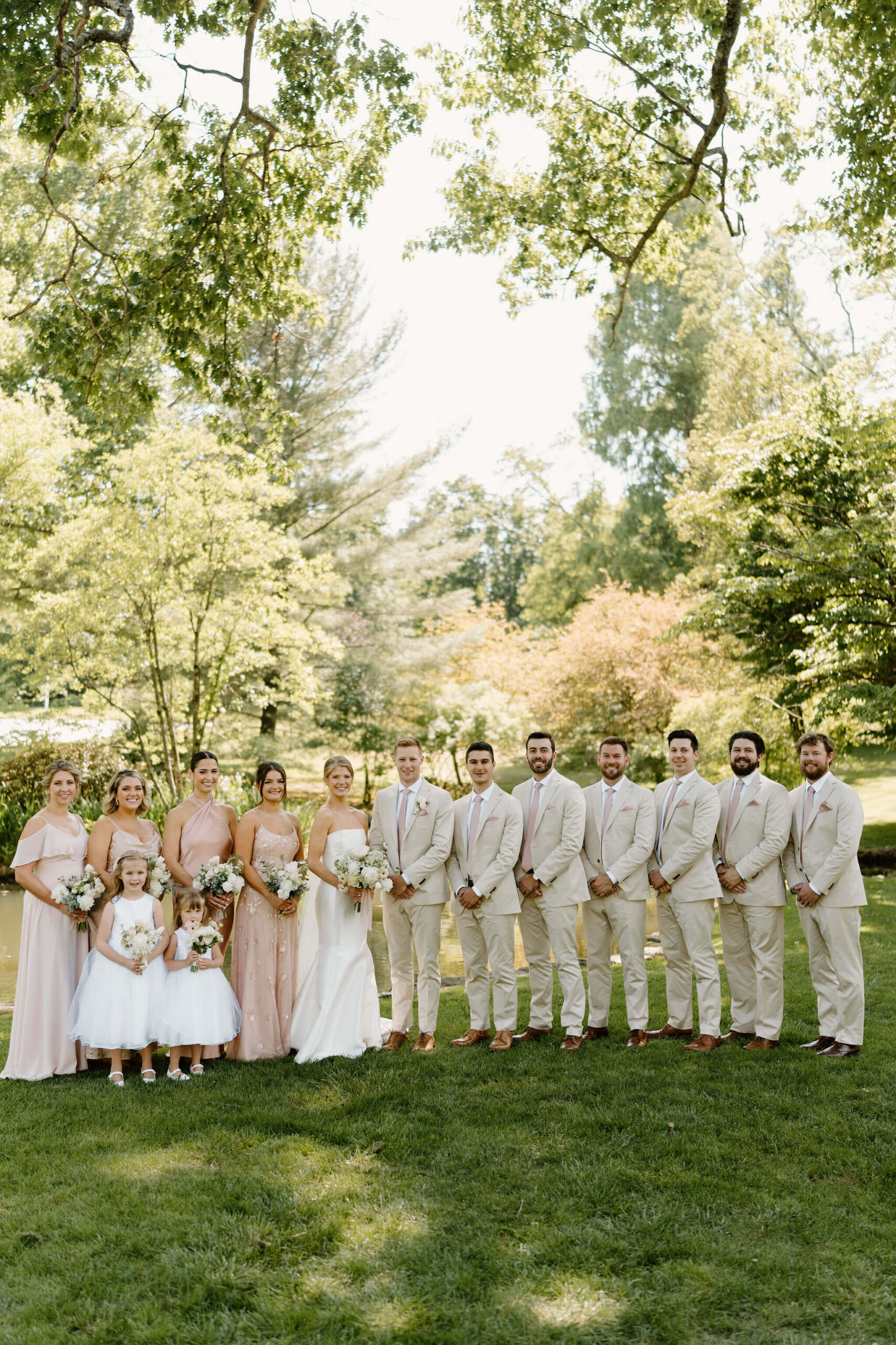 wedding party standing in a line and smiling at the camera