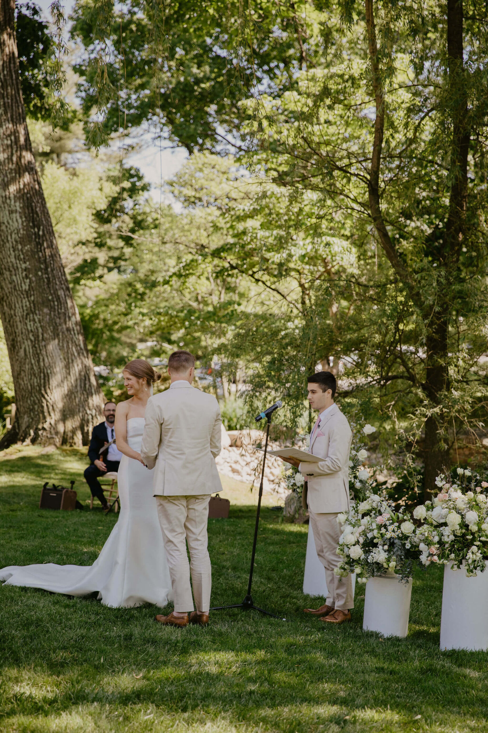 bride smiling at guests and holding groom's hands during wedding ceremony
