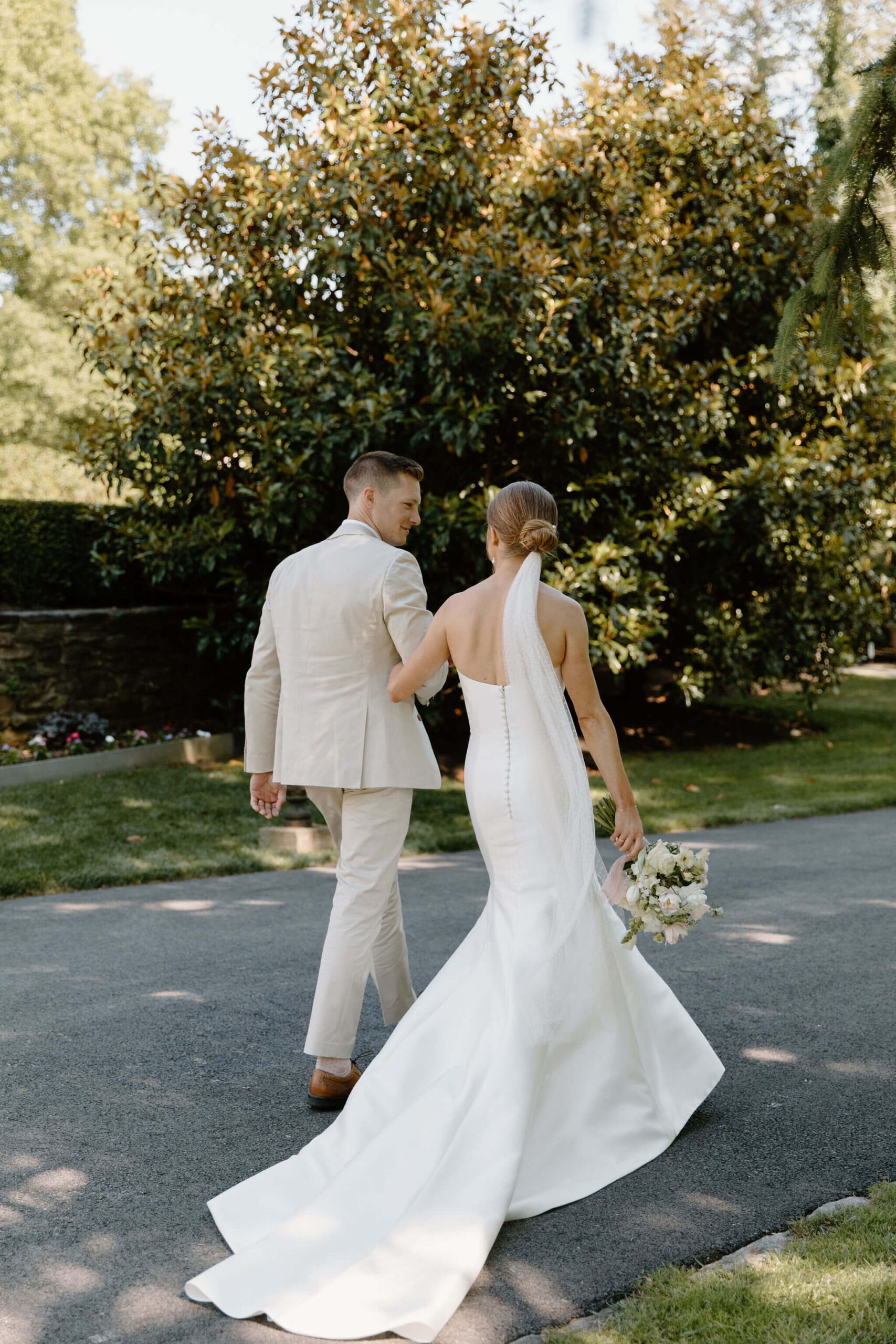 bride and groom holding hands and walking away from their wedding ceremony, smiling at each other
