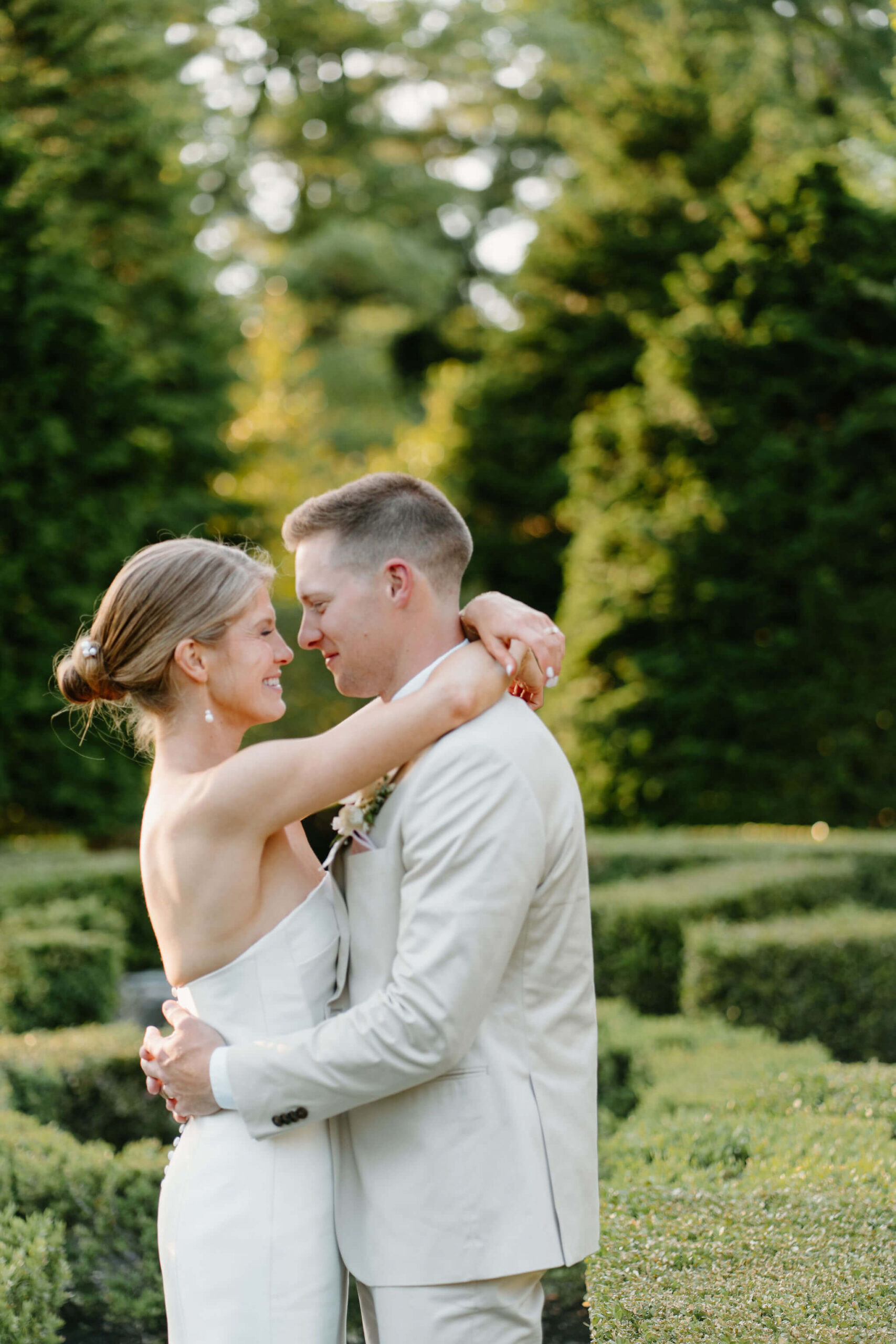 close up image of bride and groom embracing and smiling at each other on their wedding day, during golden hour portraits on their spring wedding day