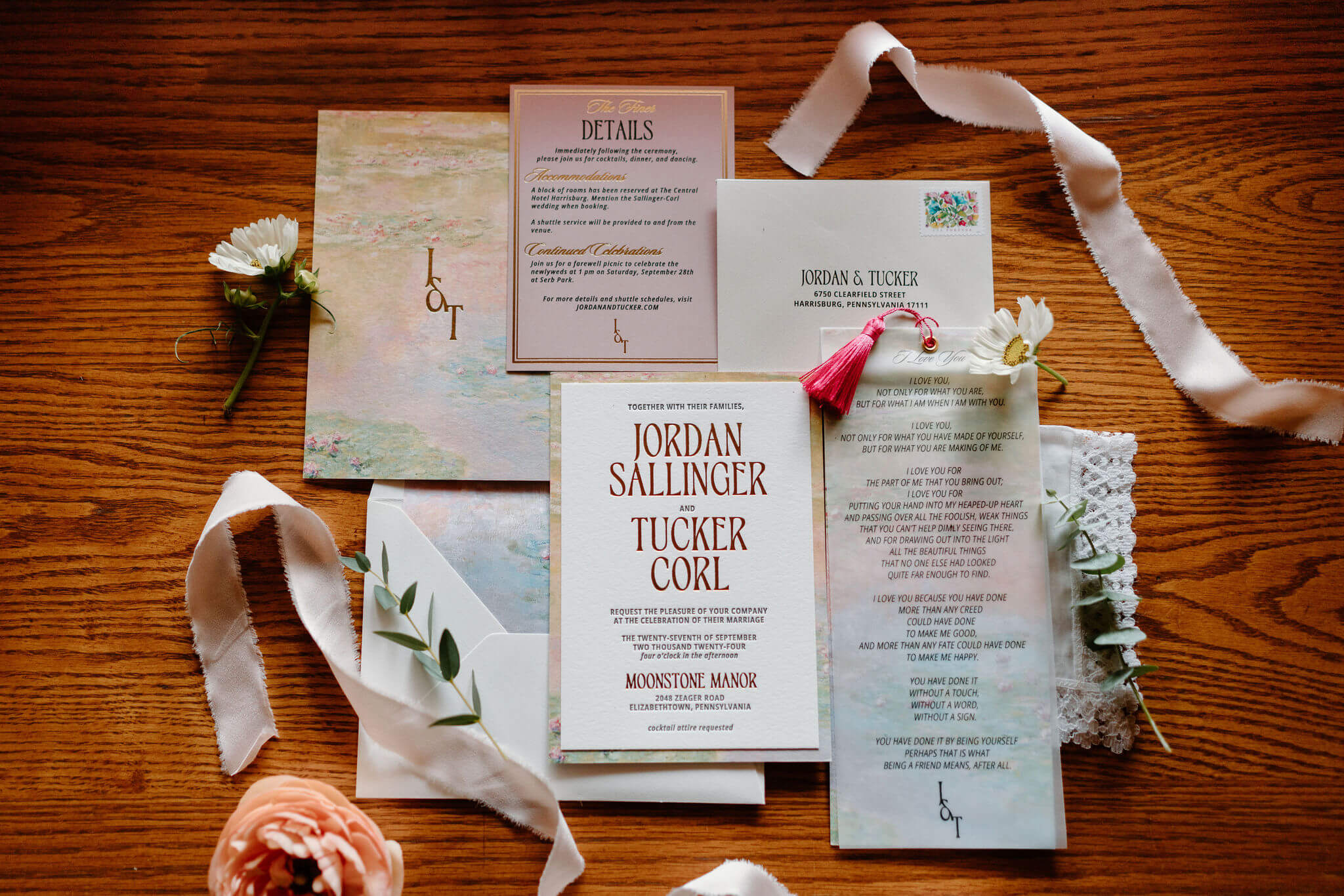 flat lay image of a custom, colorful, DIY stationery set of wedding invitations, menu, and safe the dates, framed by flowers and ribbons