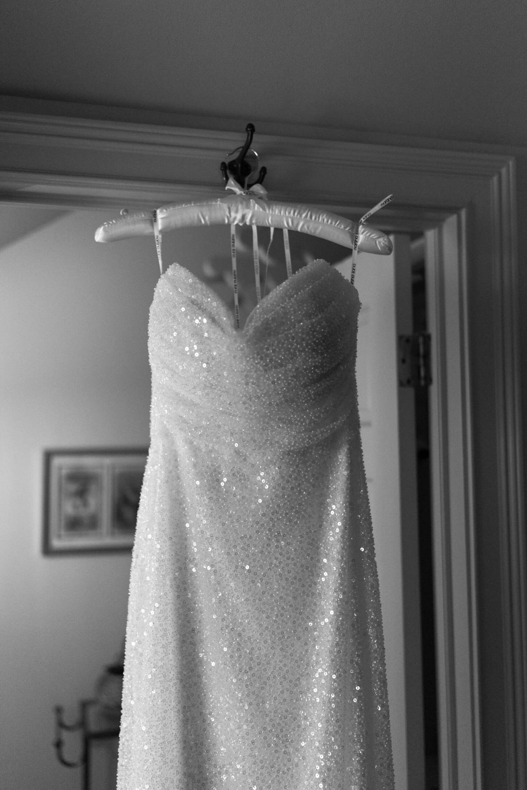 close up black and white image of bride's wedding dress, dripping in sequins and sparkling in any light it soaks up