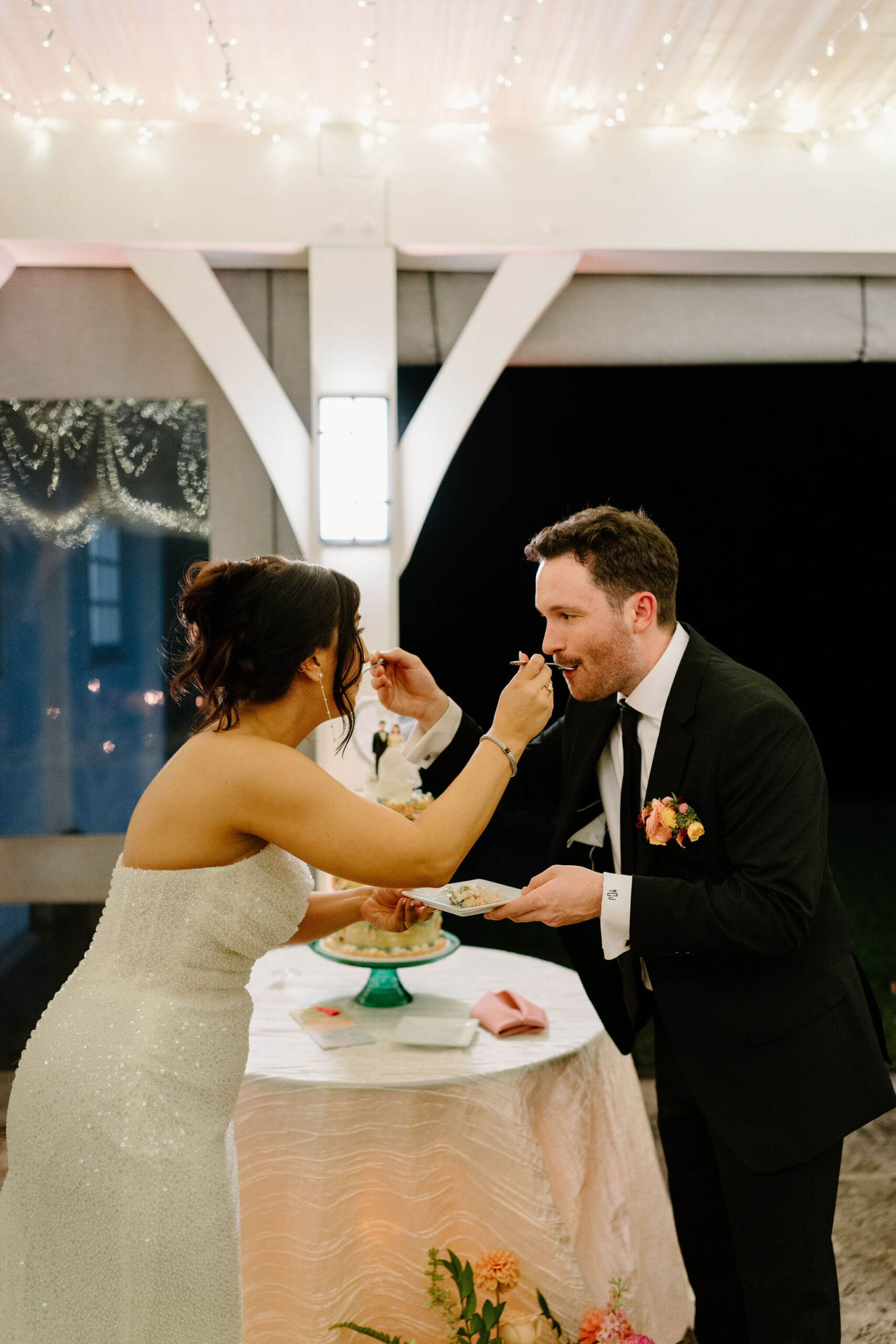bride and groom feeding each other a bite of their wedding cake