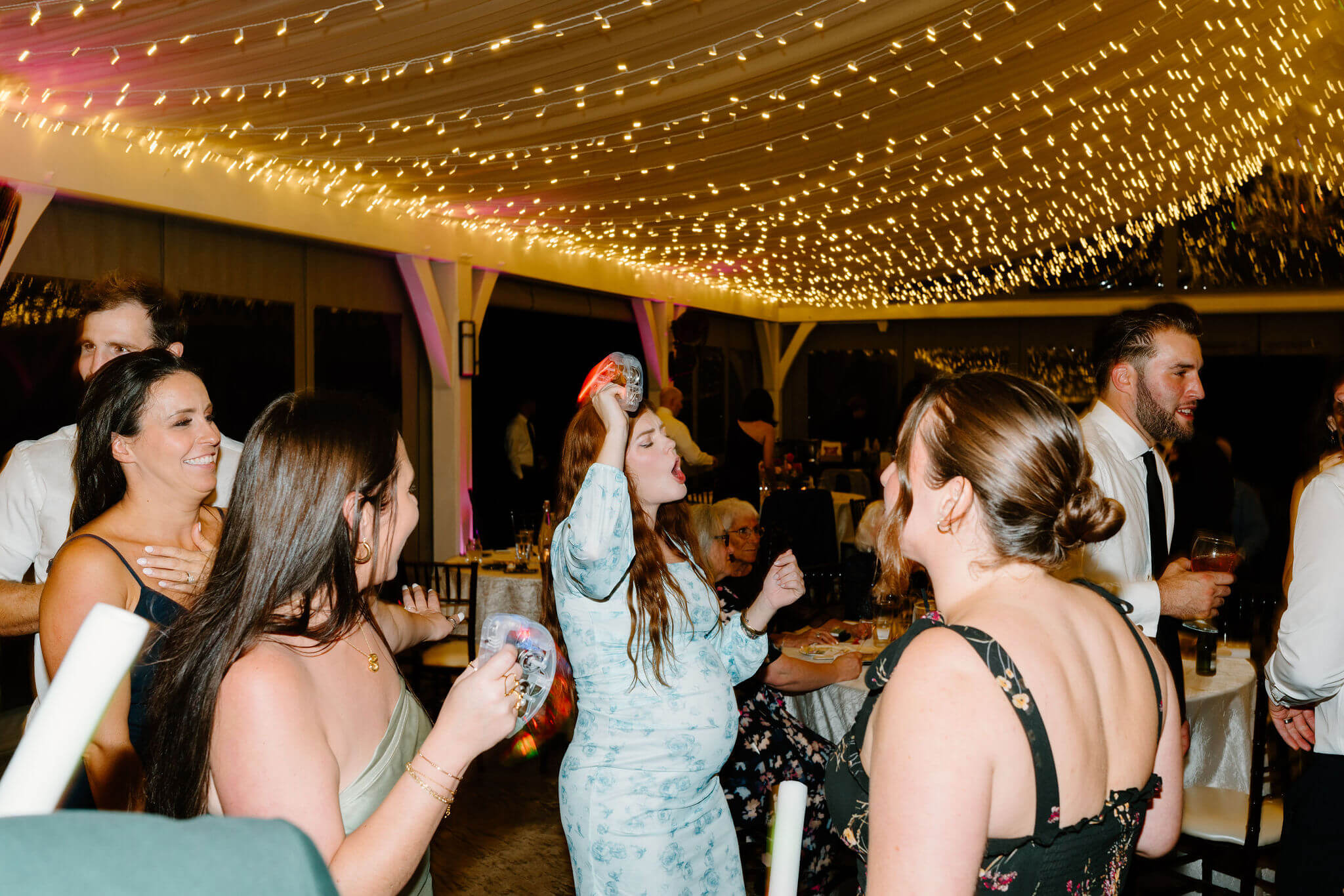 pregnant wedding gust dancing with a Tamborine during wedding reception