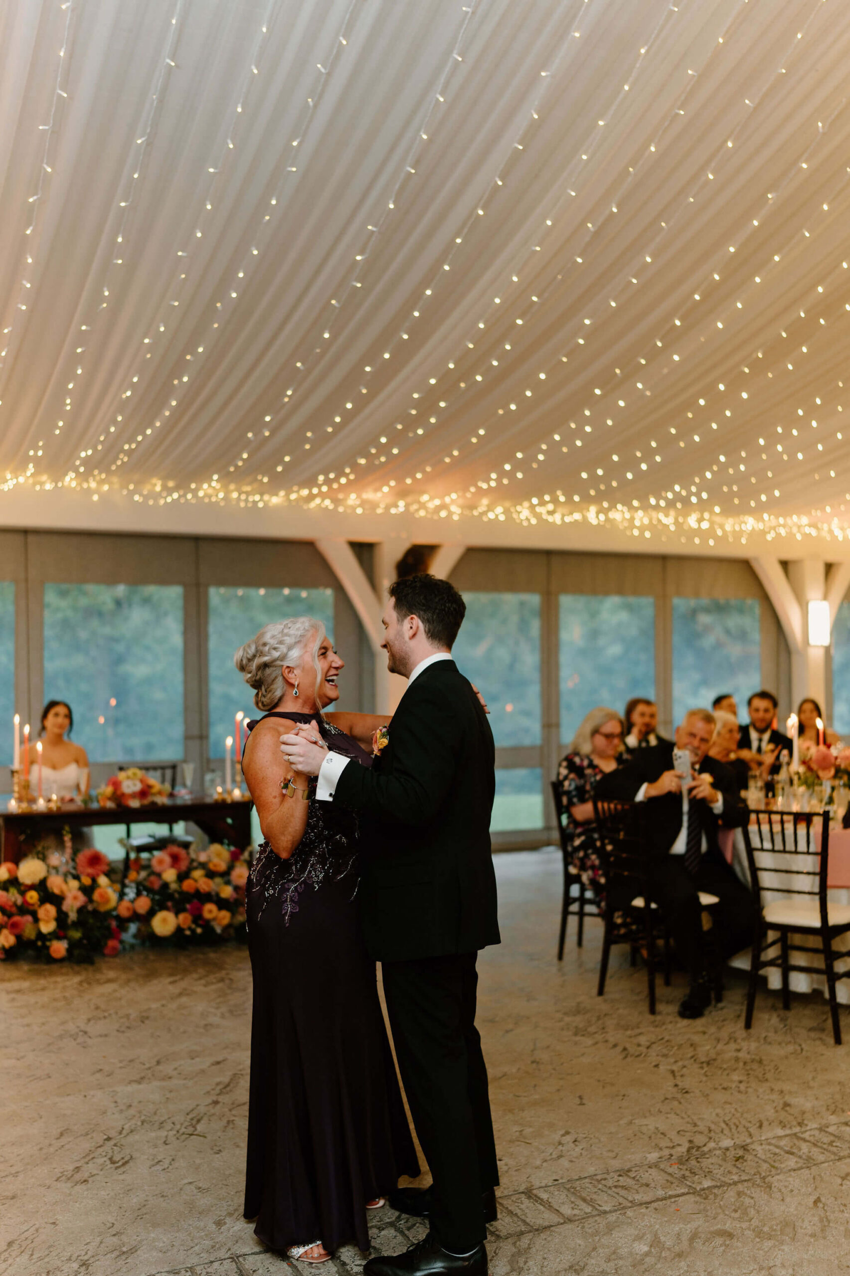 groom and his mother laughing during the mother/son dance