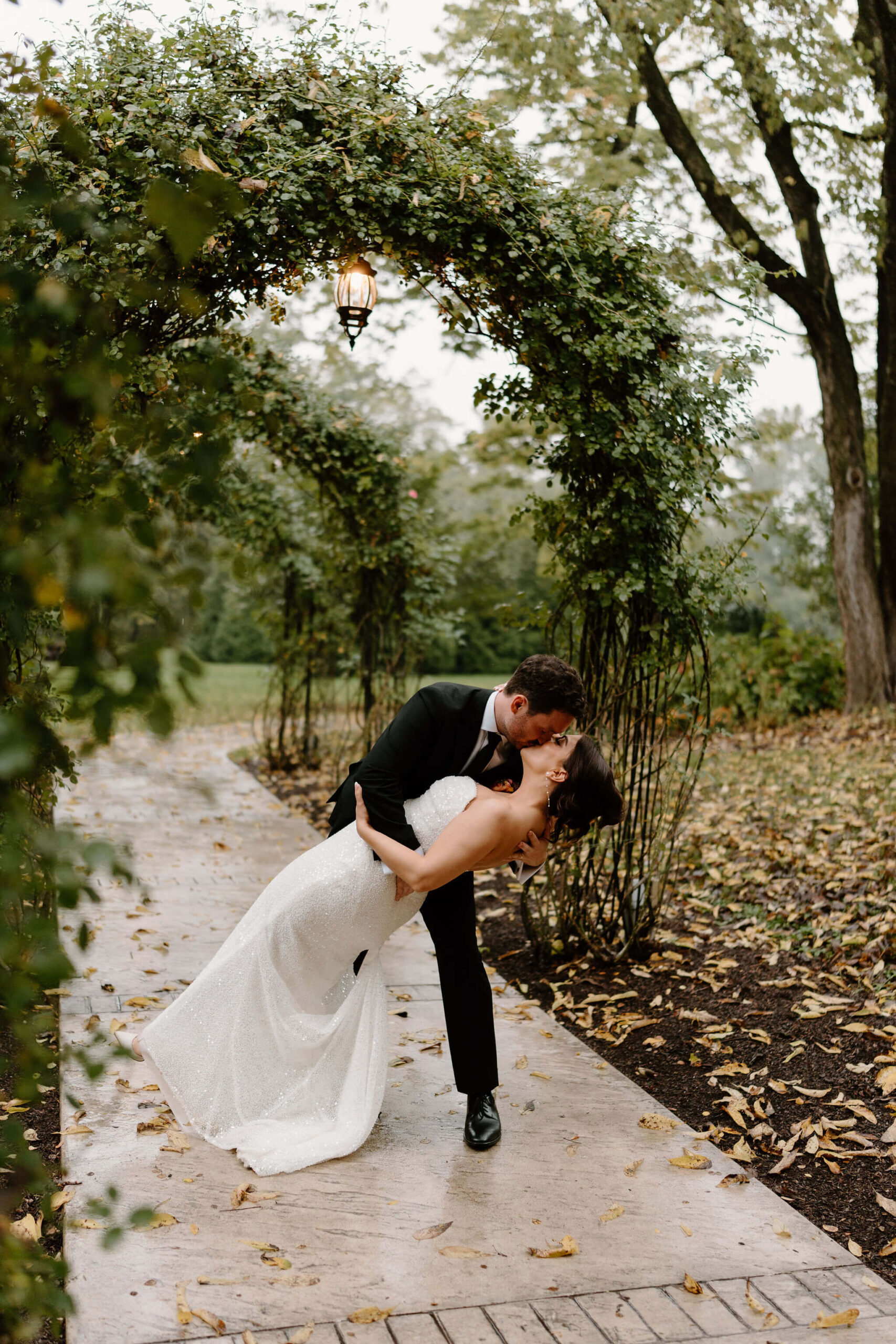 groom dipping his bride during golden hour portraits on a garden walkway