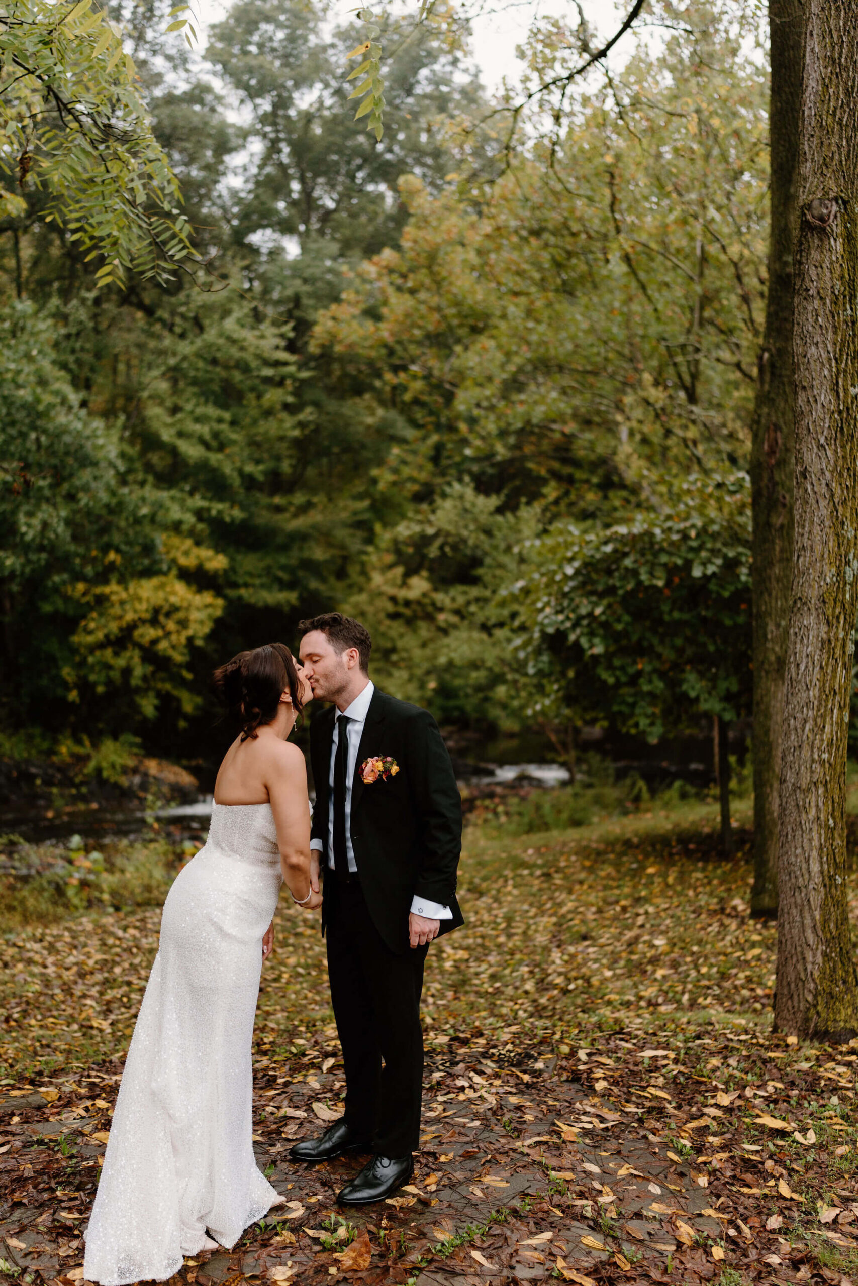 bride and groom sharing a kiss in a beautiful autumn woodsy setting