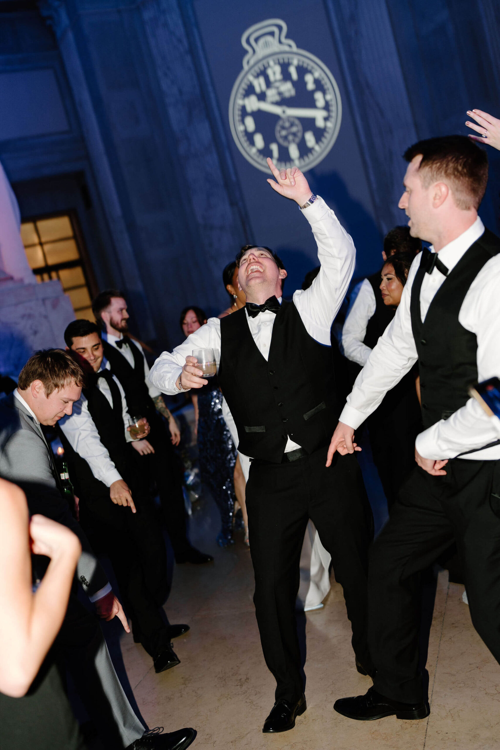 groom with his arms in the air, dancing during his wedding reception