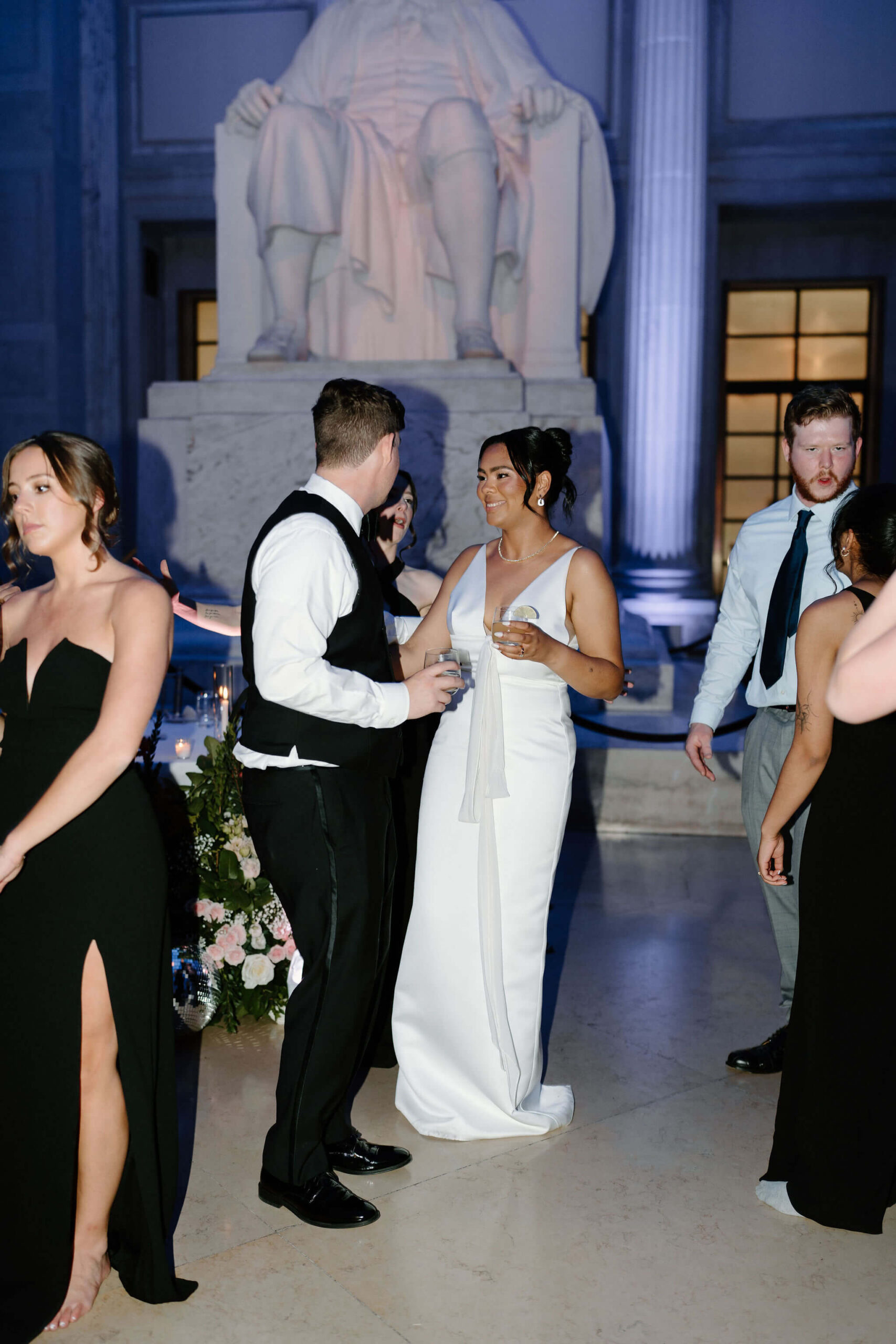 bride and groom standing near each other and smiling during their wedding reception