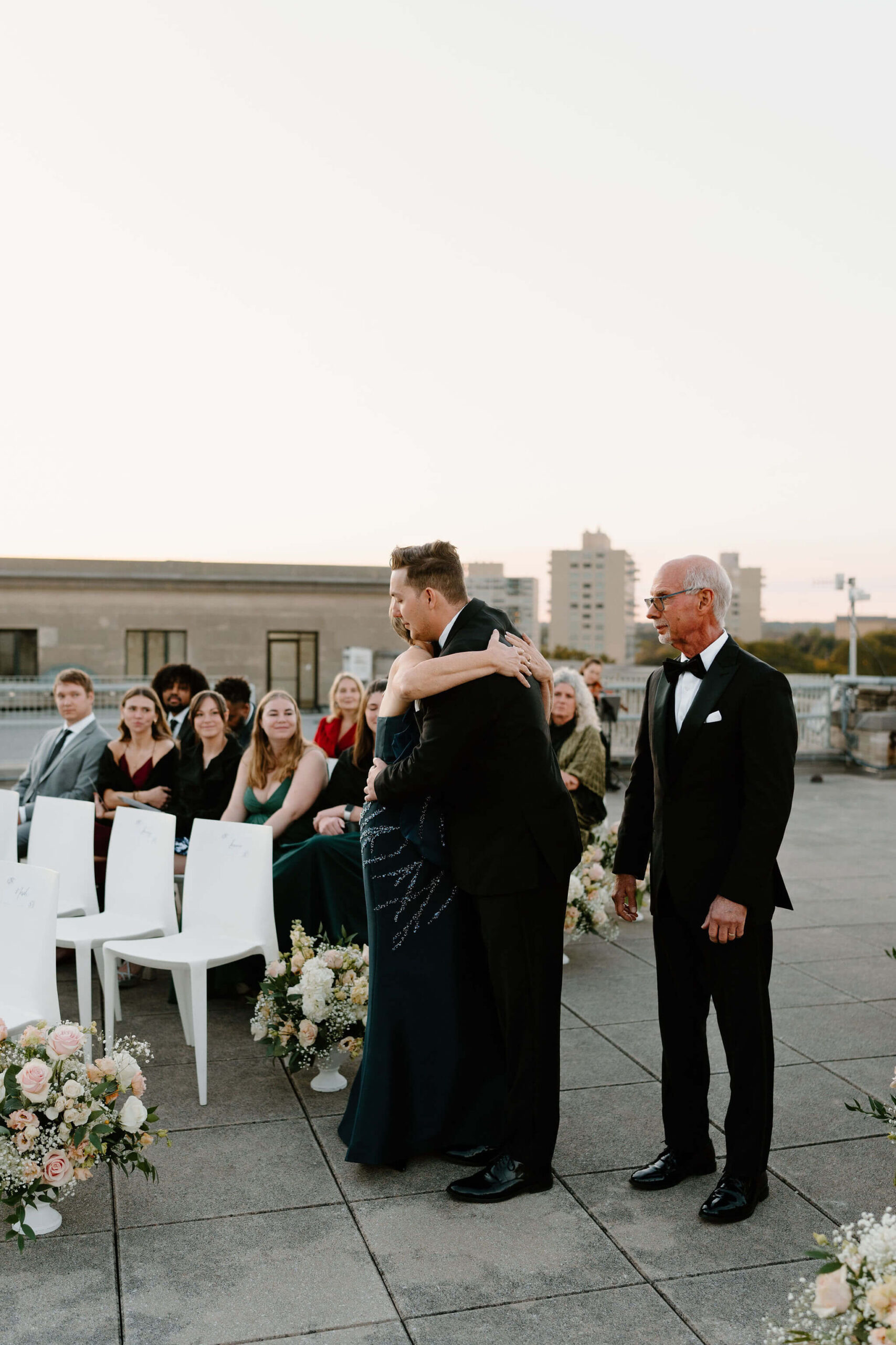 groom embracing his mother at the end of the aisle at his franklin institute wedding ceremony