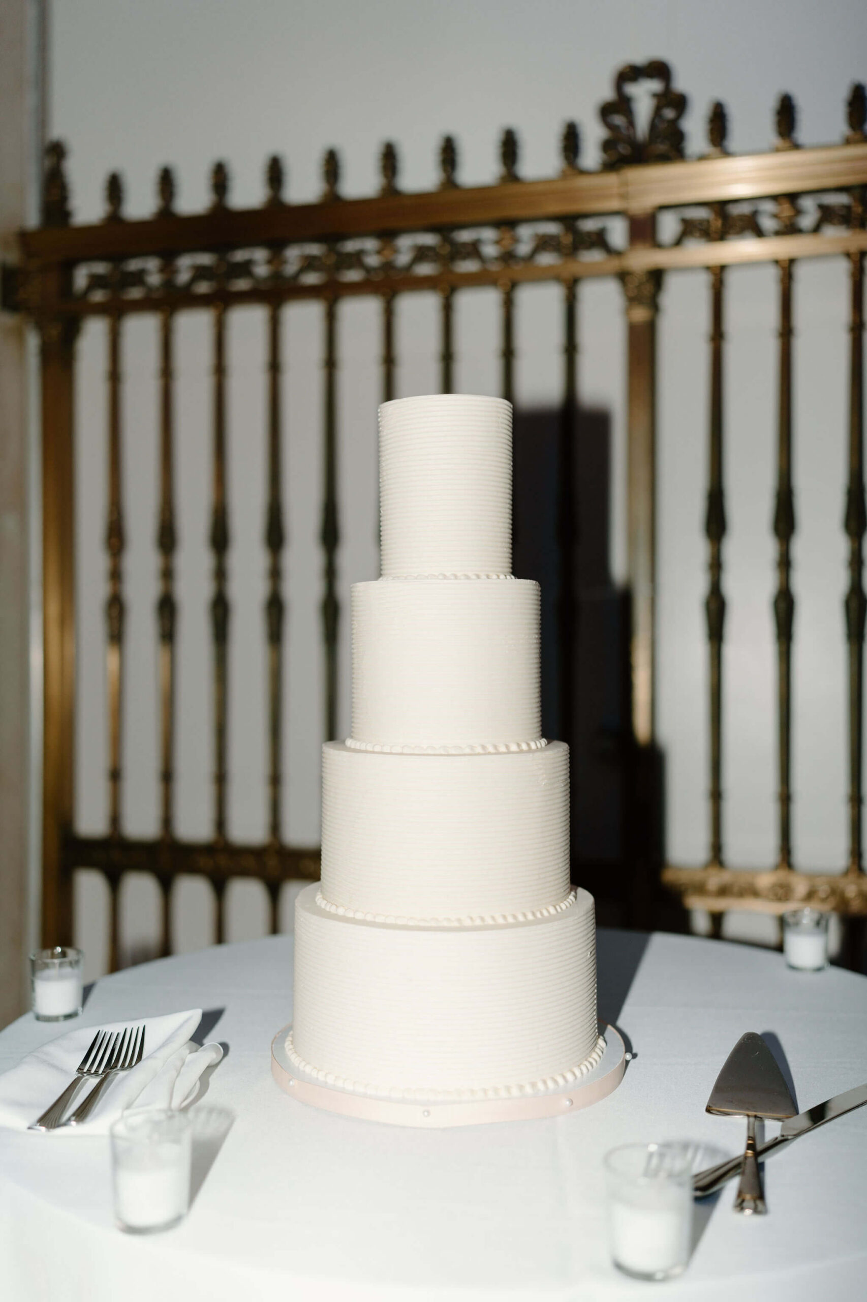 a large, all-white, four-tiered wedding cake