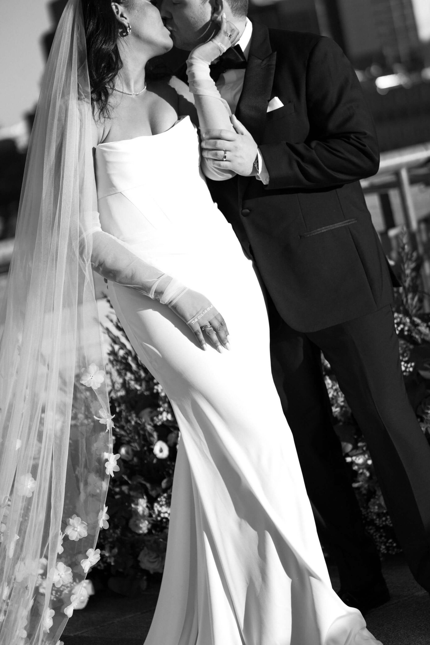 black and white image of bride and groom kissing, her hand holding his face