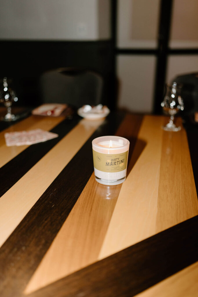 a lit candle with the label "Dirty Martini" as part of a centerpiece