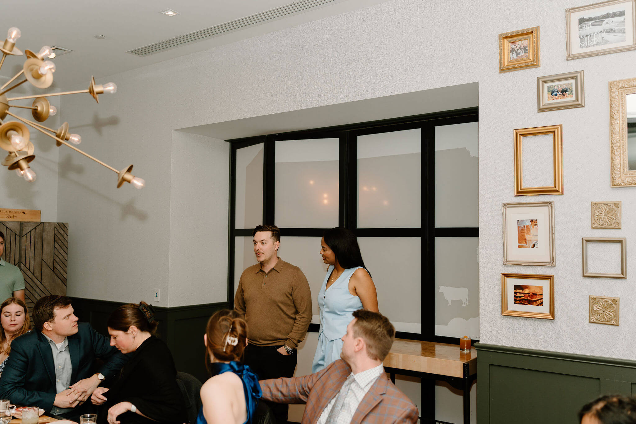 bride and groom giving a welcome speech in front of their seated guests at their rehearsal dinner