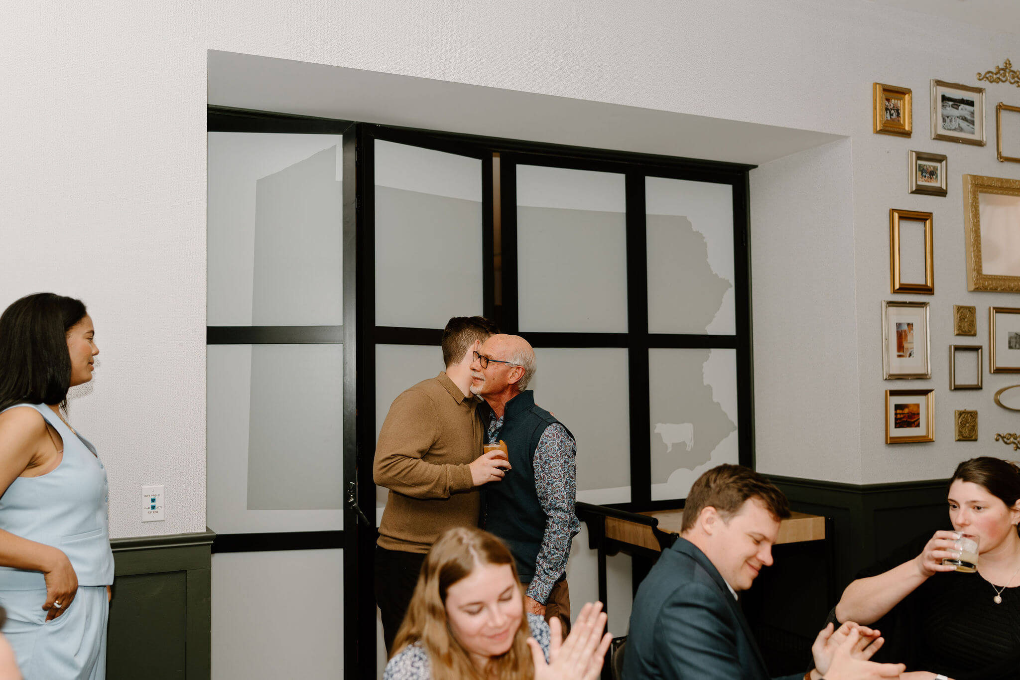groom embracing his father after giving a speech at his rehearsal dinner