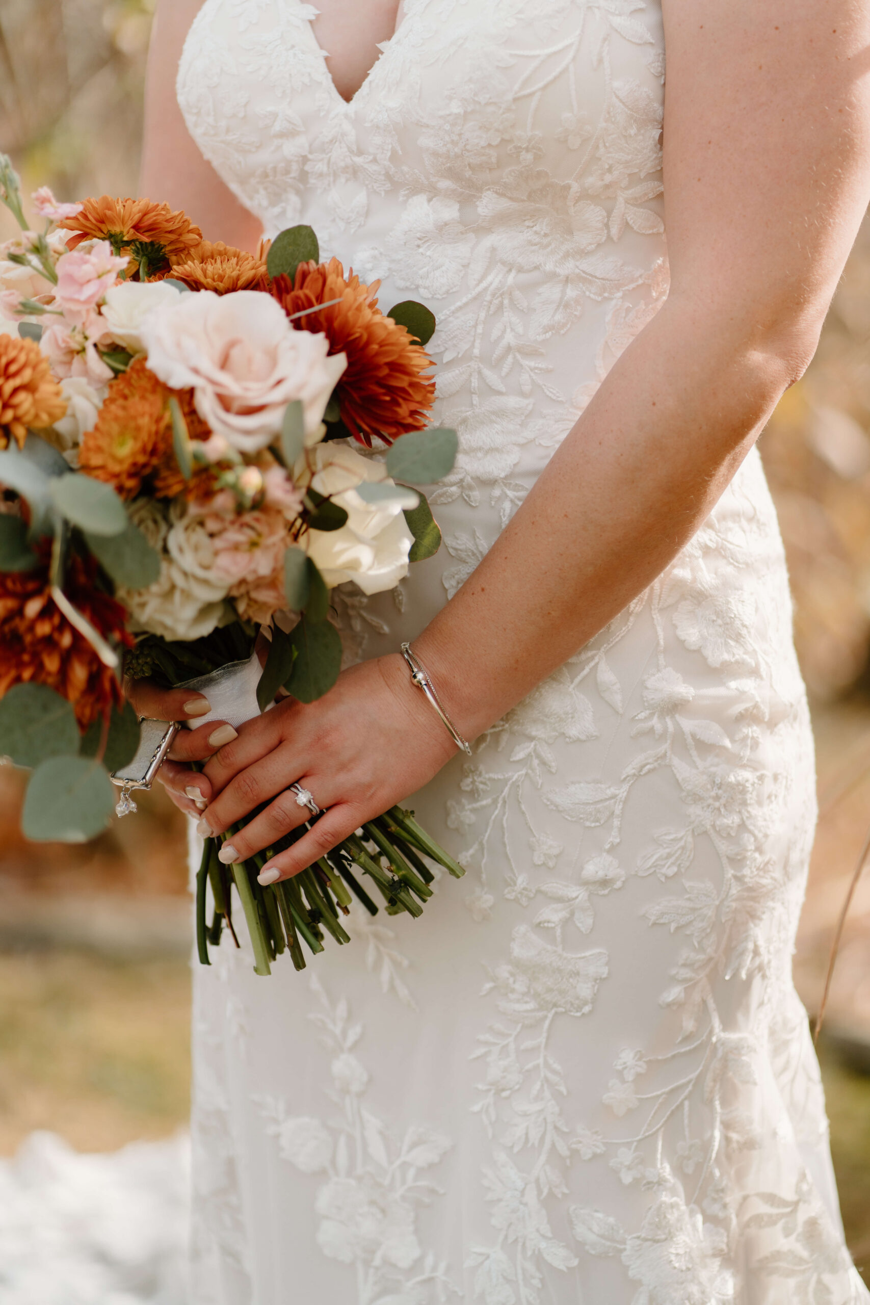 close-up of bride's engagement ring as she holds her bridal bouquet