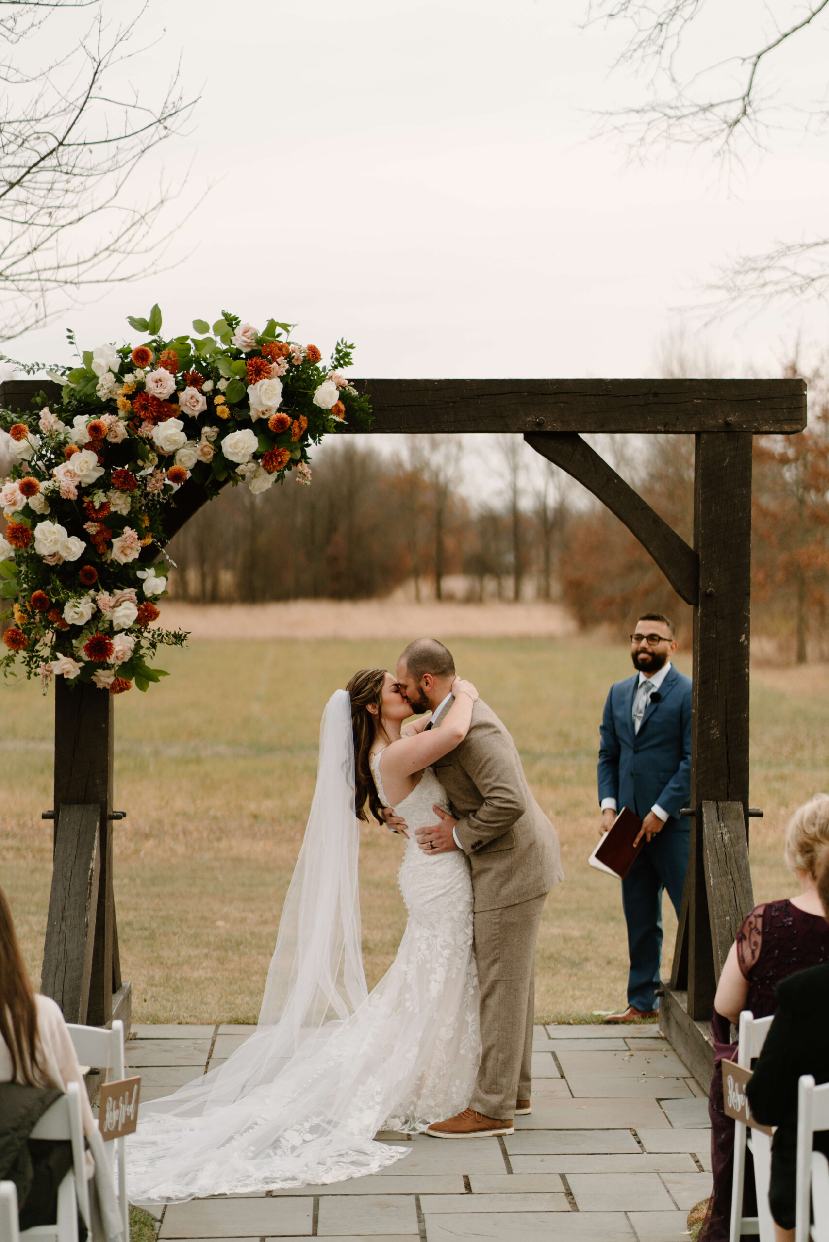 bride and groom's first kiss after their November wedding ceremony at the Farm Bakery and Events in Quakertown, Pennsylvania