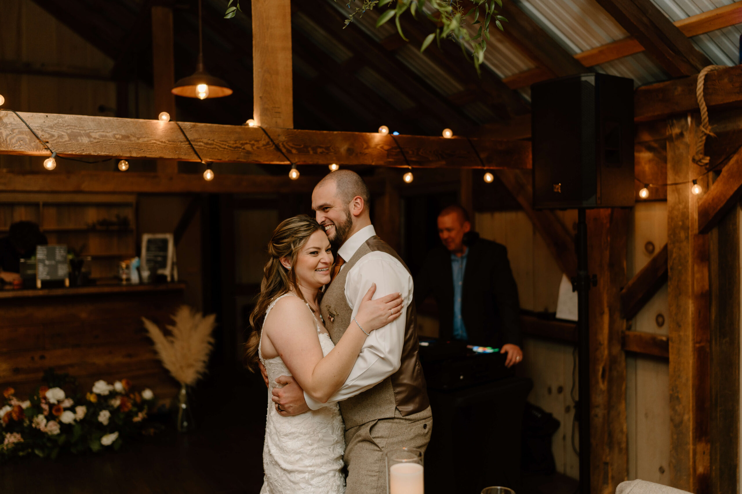 bride and groom embracing and laughing widely at their November wedding reception at the Farm Bakery and Events